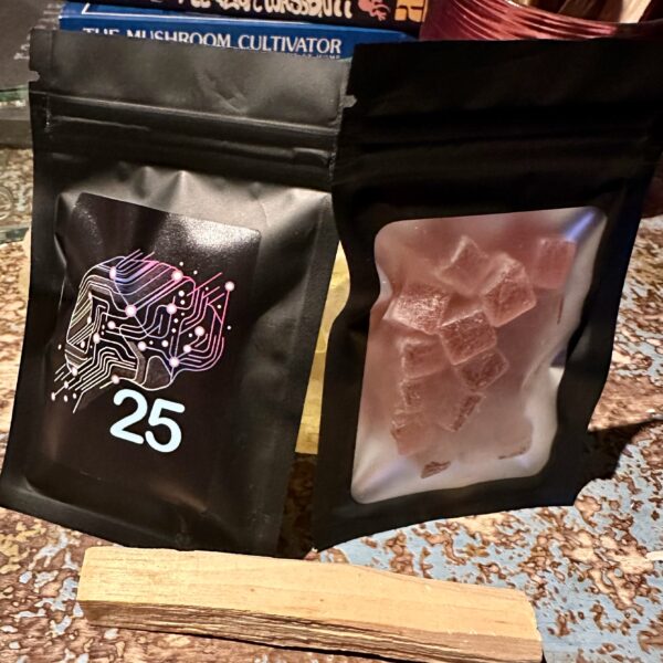 Two black resealable pouches labeled “25,” one containing pink gummies and the other sealed, displayed on a wooden surface.